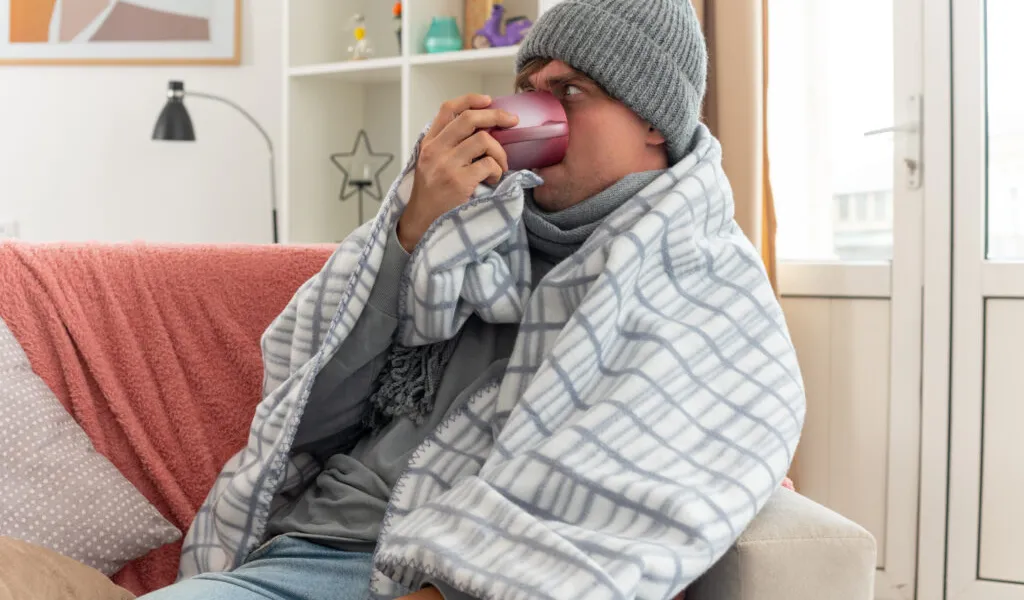 Person feeling cold indoors needing energy efficient windows