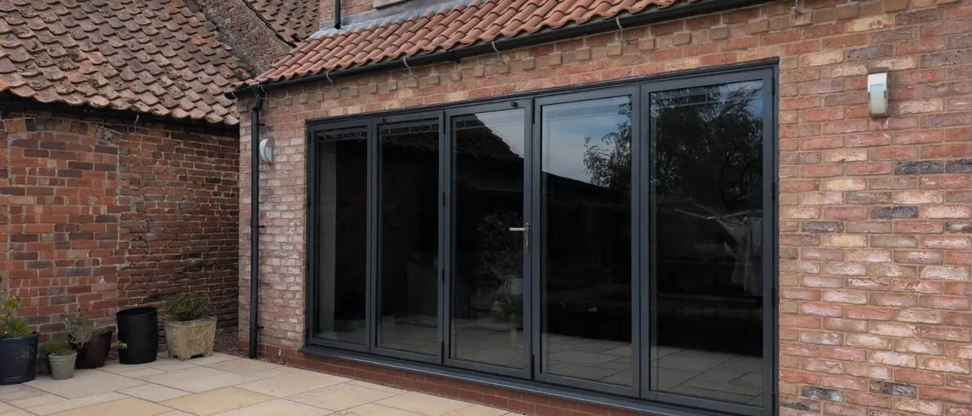 Anthracite Grey 5-panel Cortizo aluminium bifold doors installed on a brick home in Grimsby
