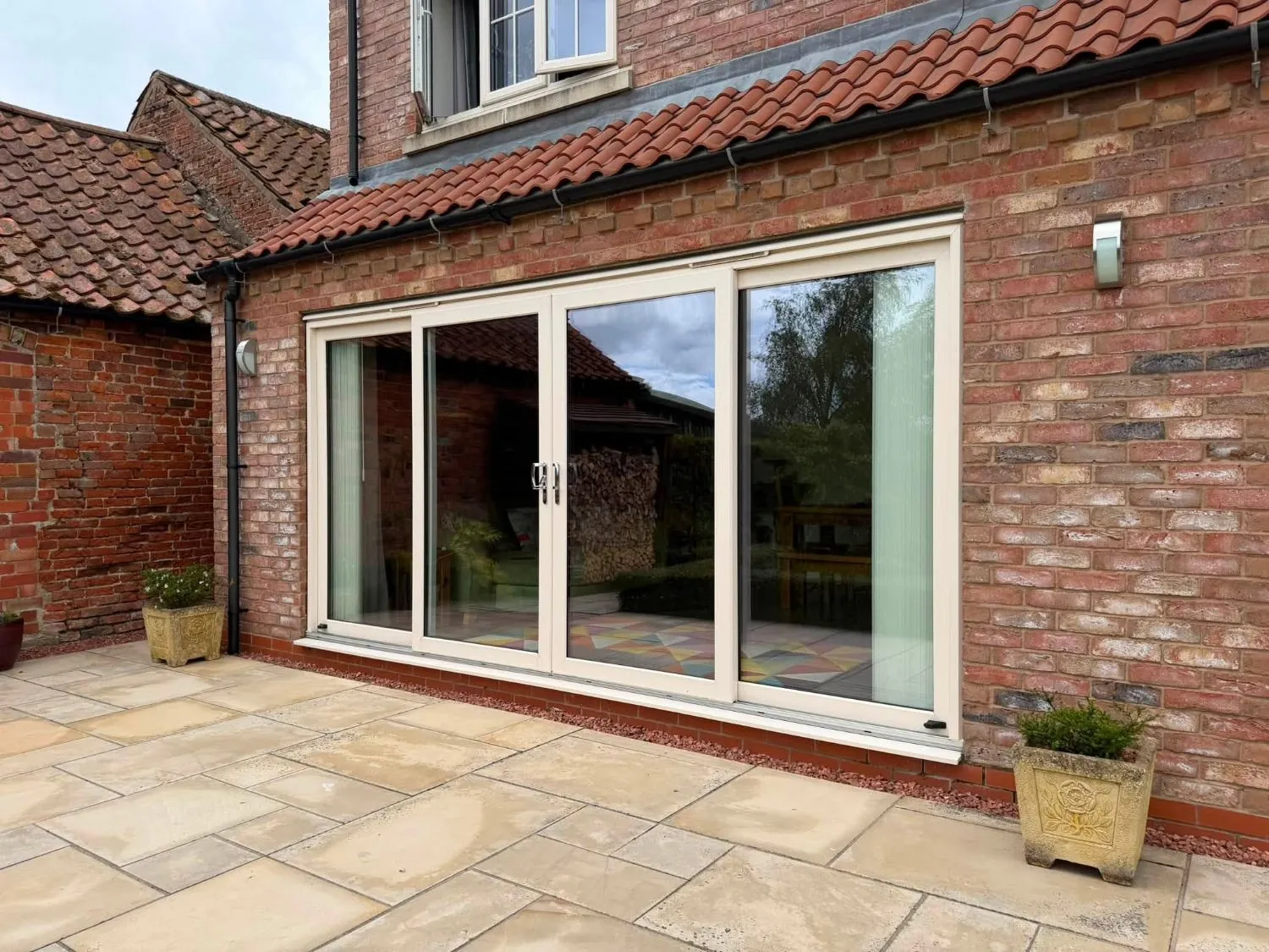 Old cream 4-panel sliding patio doors at the rear of the property before replacement