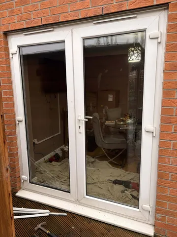 Old white uPVC French doors at the rear of the property before bifold installation