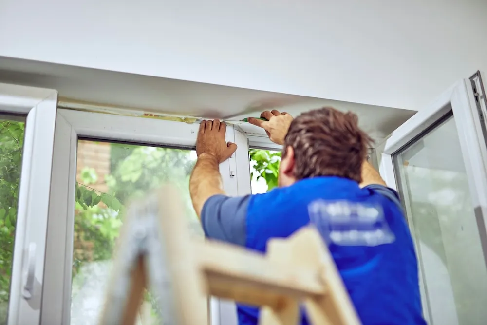 Engineer fitting a UPVC window during a rental repair call-out