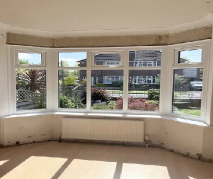 Front bay window after replacement, with new white UPVC frames and top-opening vents